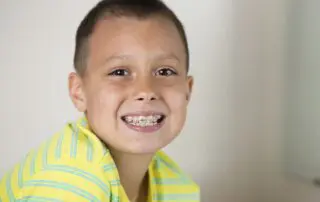 Boy showing his teeth braces.